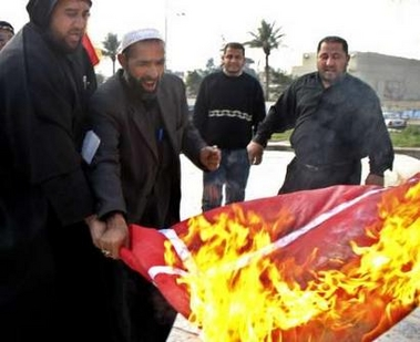 Iraqi Shi'ite clerics burn a flag of Denmark
